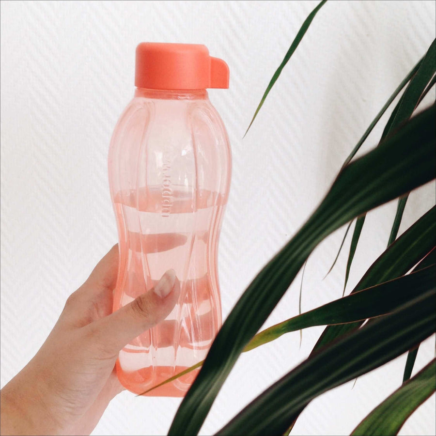 Hand holding a pink reusable water bottle