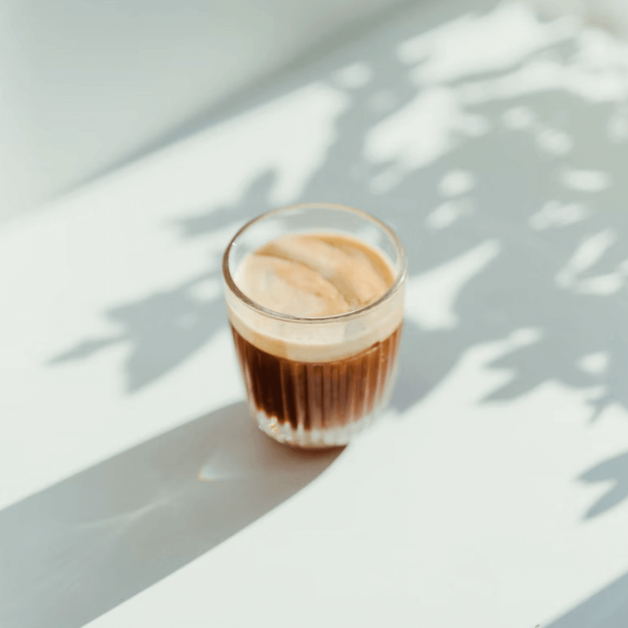 Glass of iced coffee in dappled sunlight