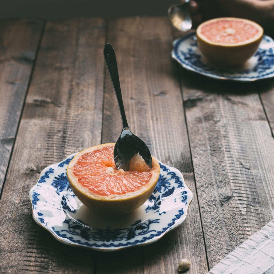 Halved grapefruit on a patterned plate