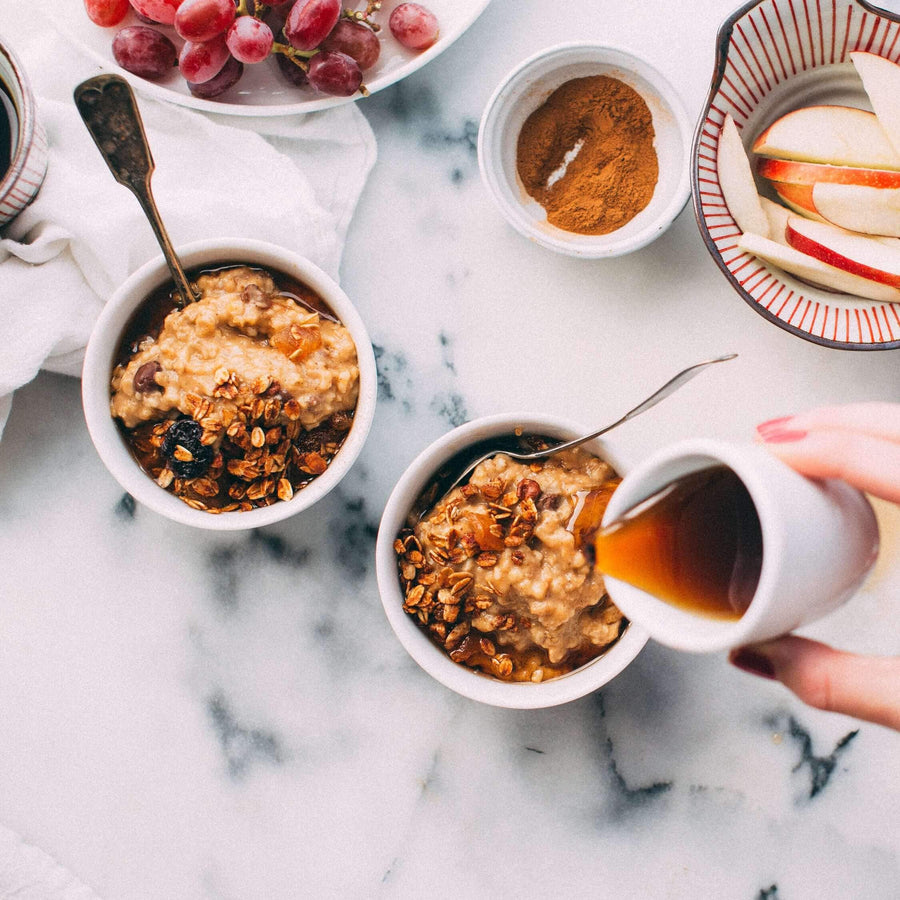 Bowls of baked oats with a jug of syrup