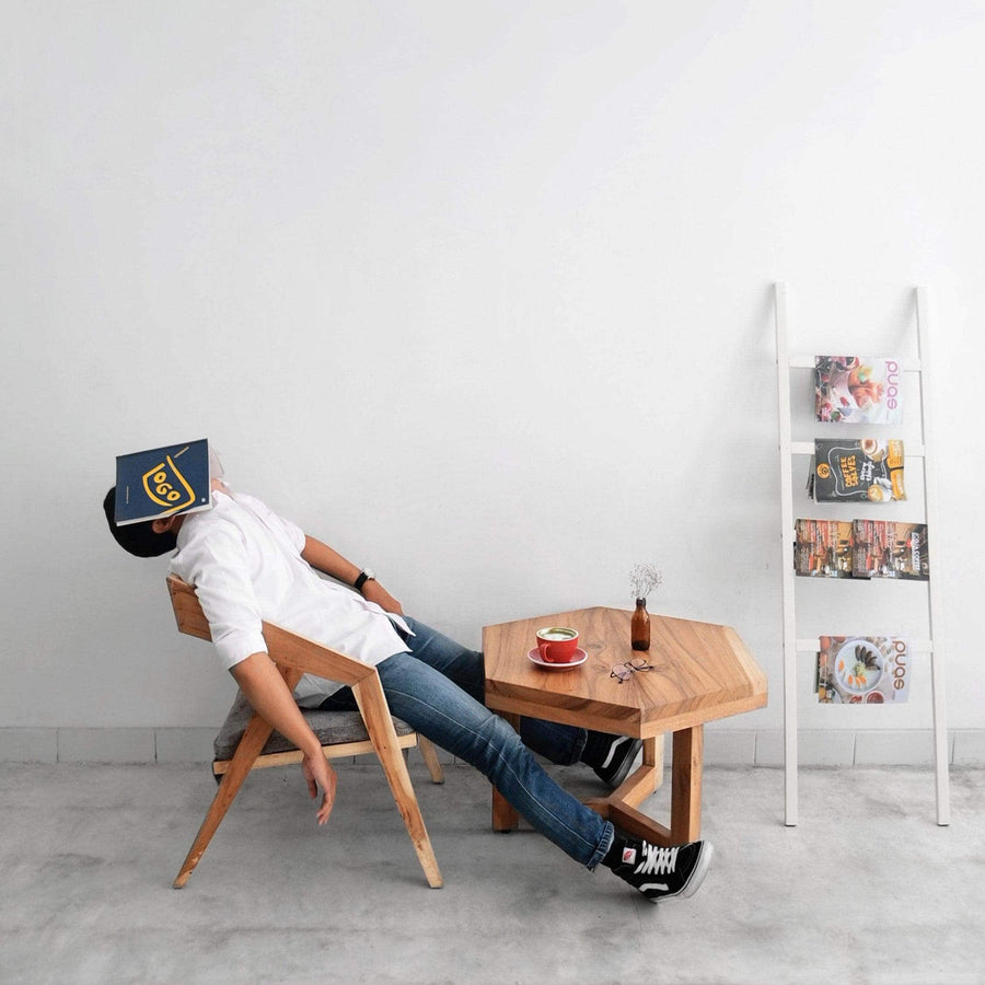 Man dozing in a chair with a book over his face