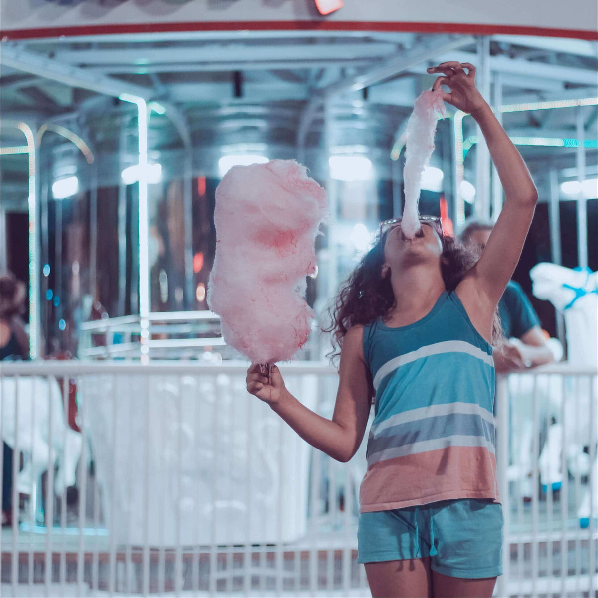 Woman eating candy floss at a funfair