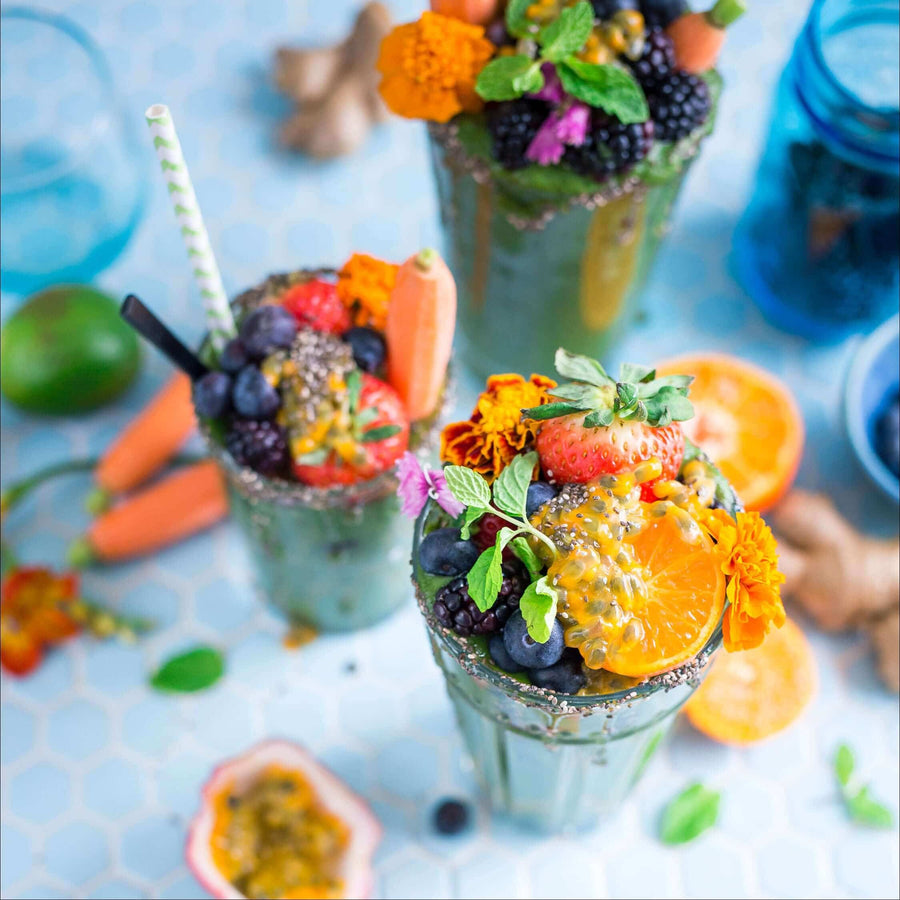 Smoothies topped with fruit and flowers
