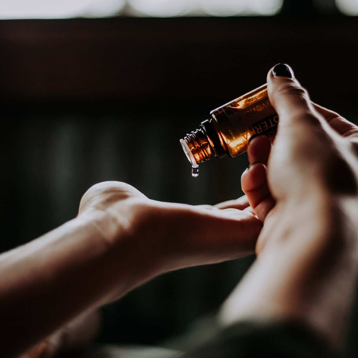 Oil dropped from a bottle onto a hand