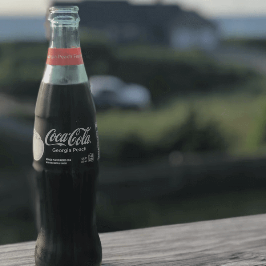 Glass bottle of cola on a wooden table