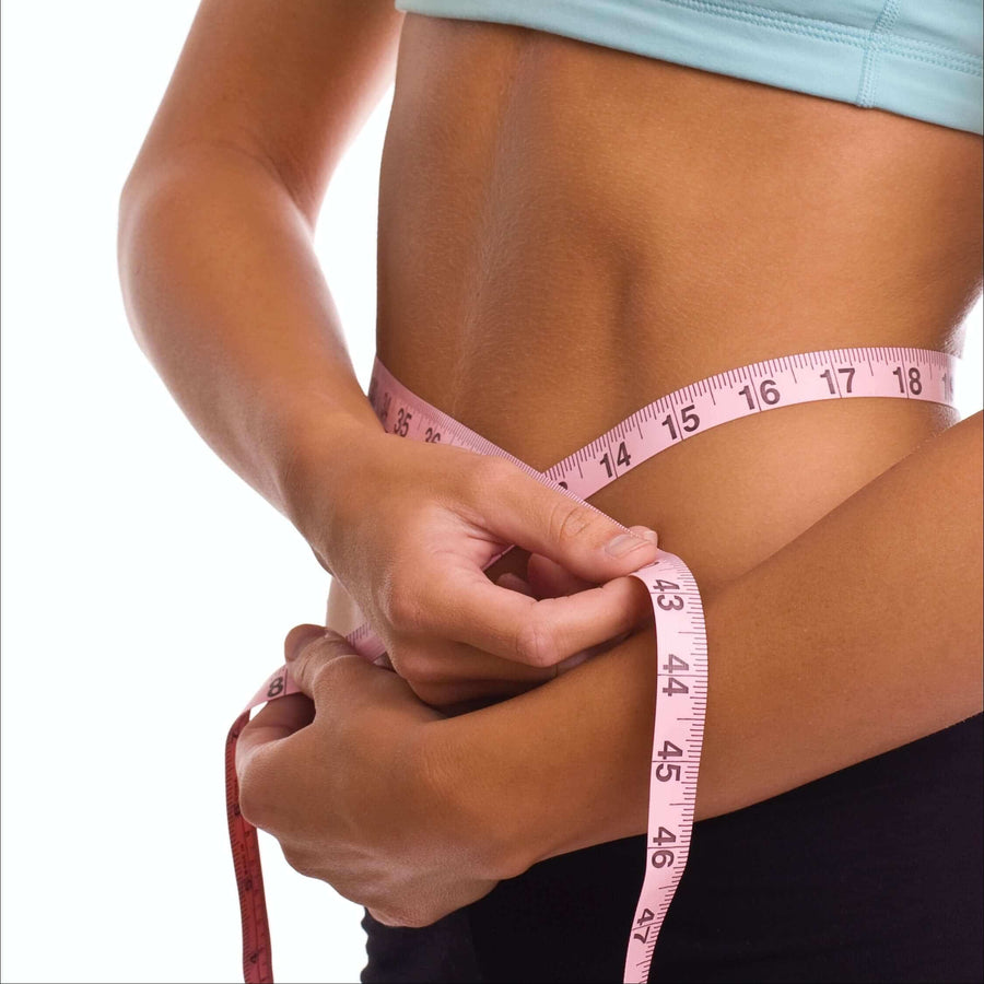 Woman measuring her waist with a tape measure