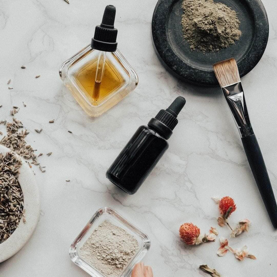 Dropper bottles of oil with powders and a brush