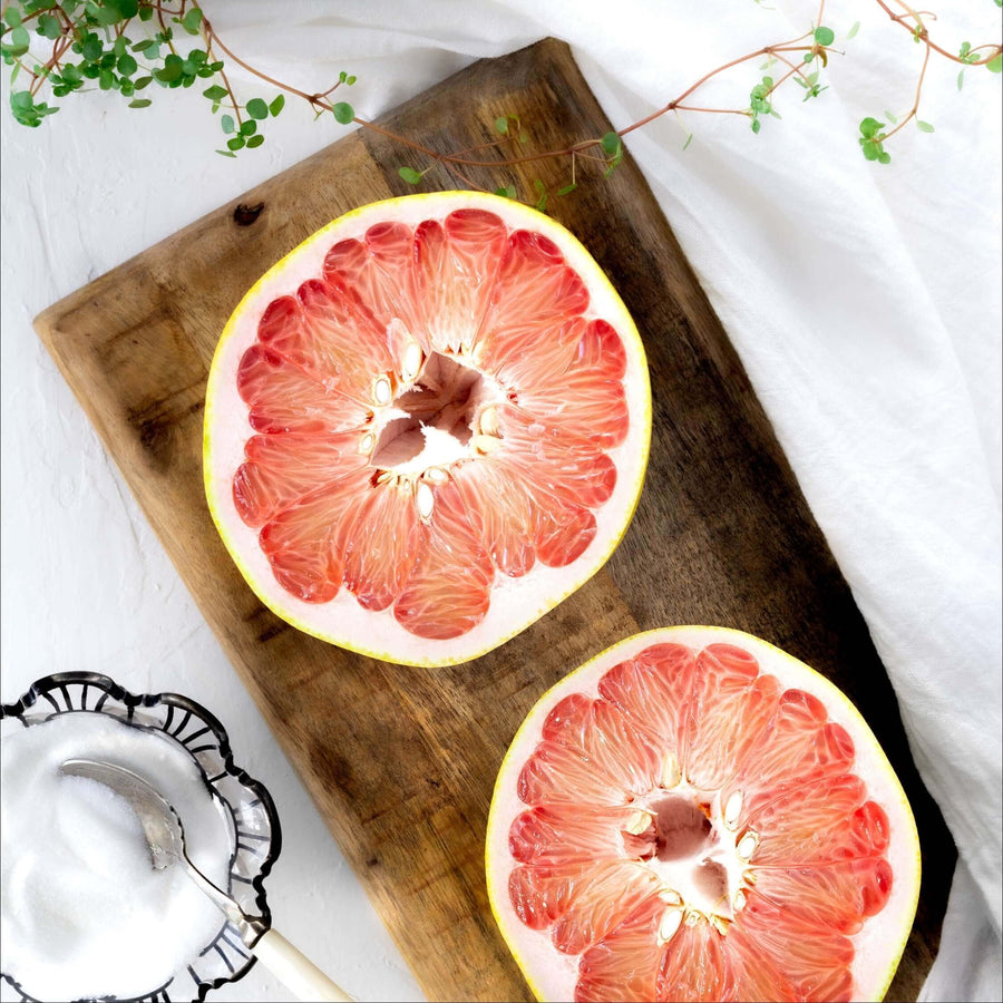 Halved grapefruits on a wooden board