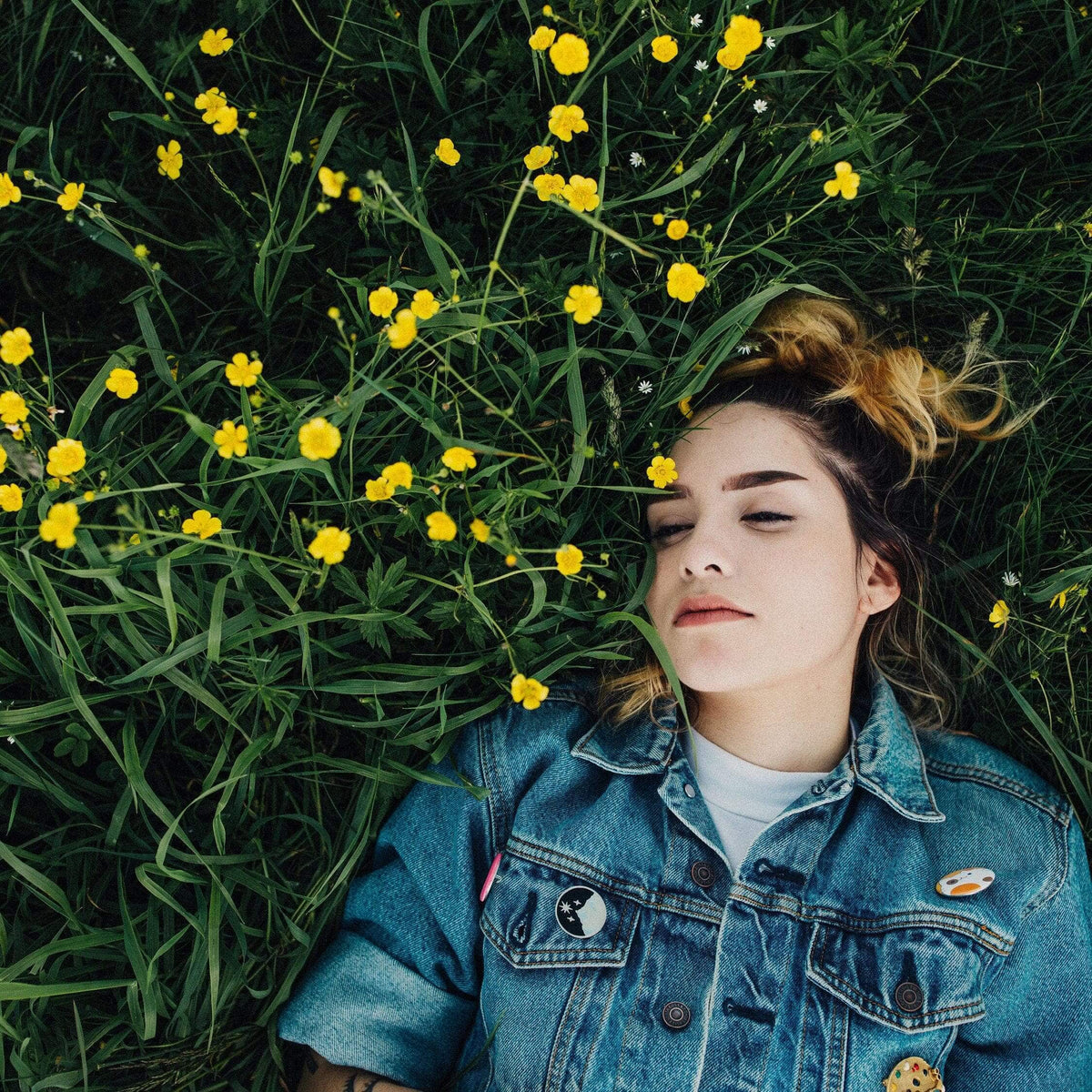 Woman lying in grass among yellow flowers