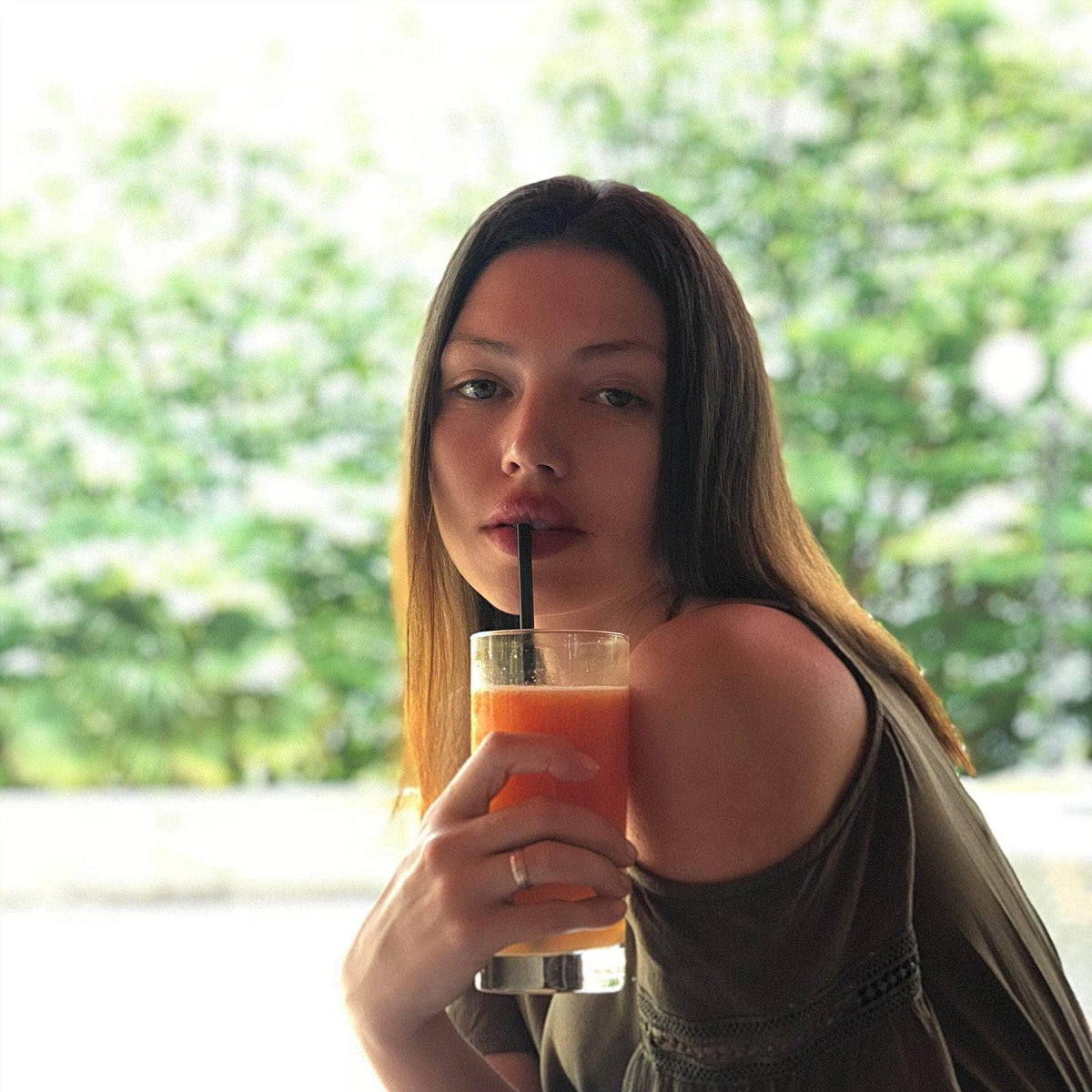 Woman drinking a juice through a straw