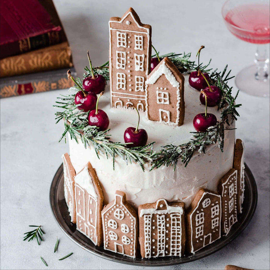 Christmas cake decorated with gingerbread houses and cherries
