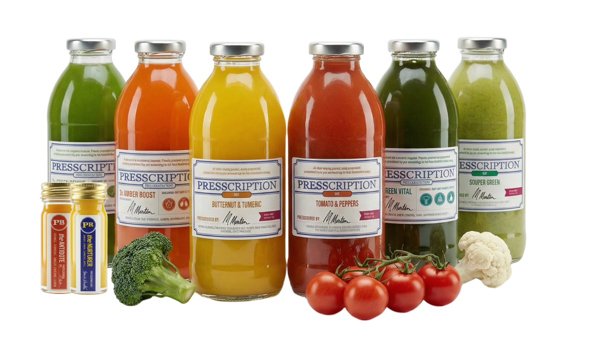 Immunity Soup Cleanse: Presscription soups and broths in glass bottles with broccoli and cherry tomatoes