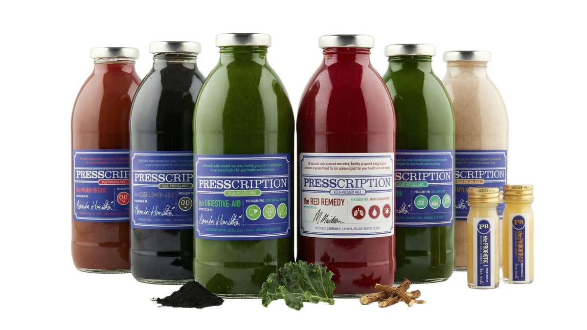 Gut Cleanse: a row of Presscription cold pressed juices and wellness shots in glass bottles with leafy greens
