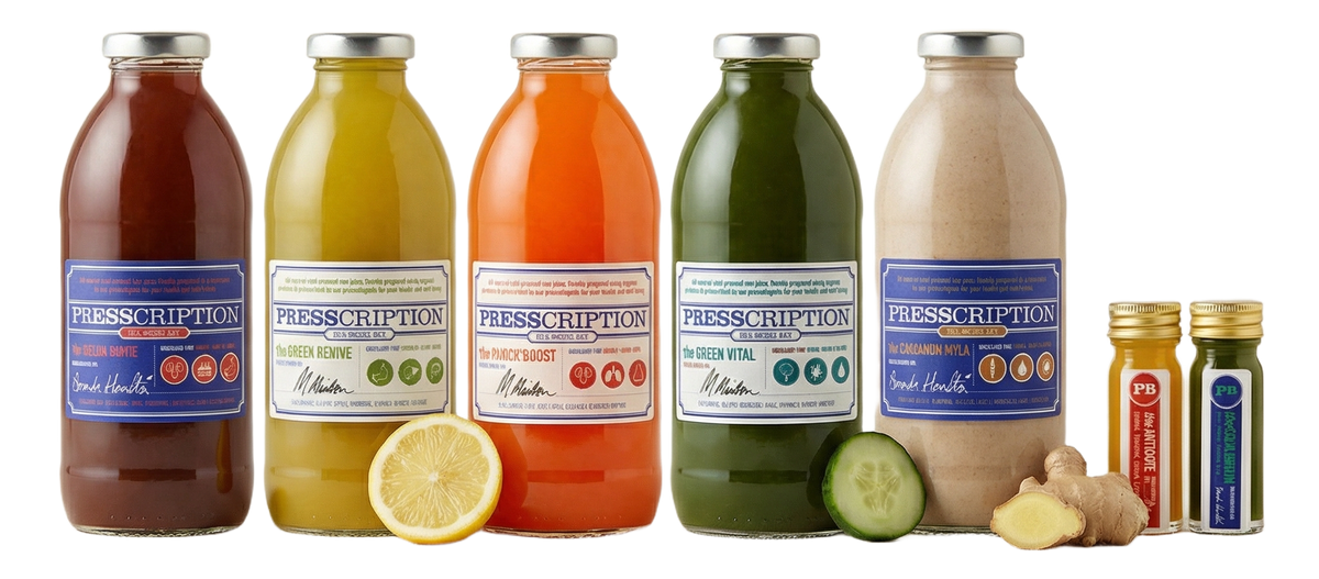 Presscription juice cleanse: a row of cold pressed juices and wellness shots in glass bottles with fresh lemon