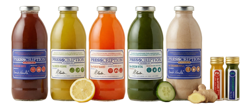 Presscription juice cleanse: a row of cold pressed juices and wellness shots in glass bottles with fresh lemon